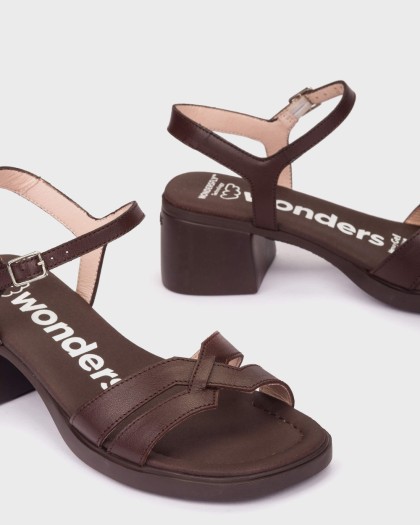 Detalle de las sandalias MOAI 07 en piel marrón oscuro con tiras cruzadas pulsera al tobillo y tacón ancho cómodo.
